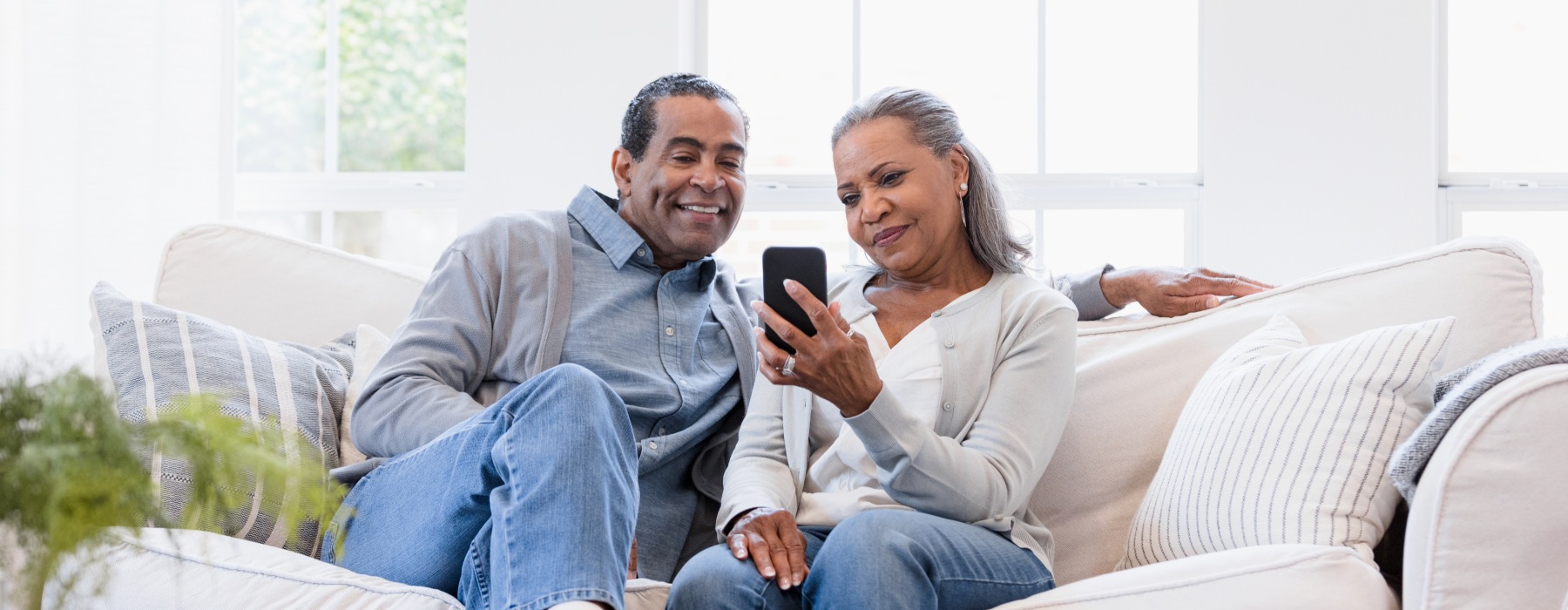 couple looking at their phone on couch